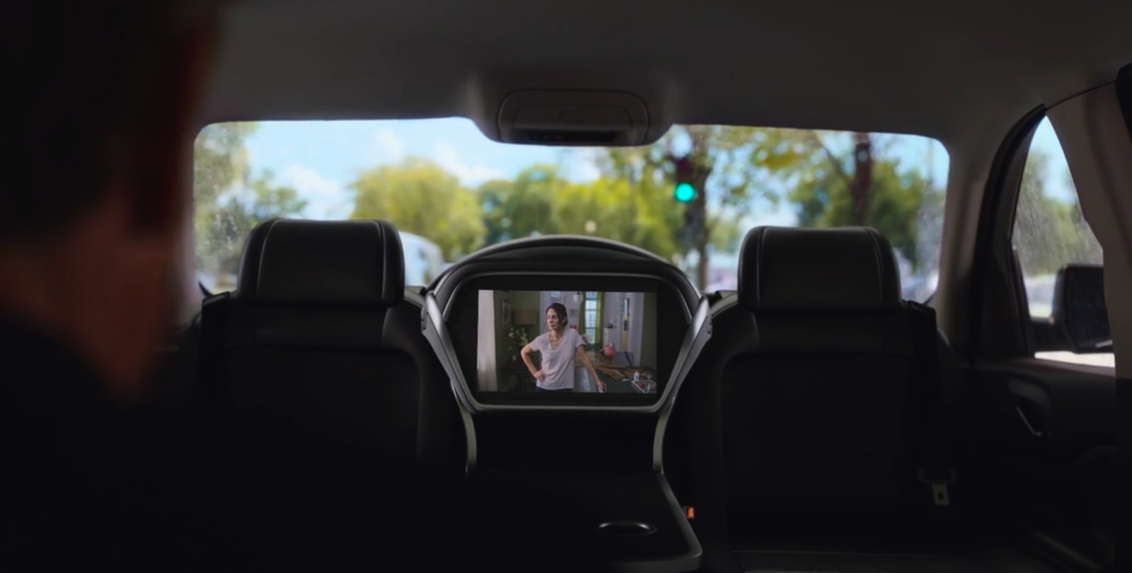 People ride a self-driving car and consume content on the infotainment system.