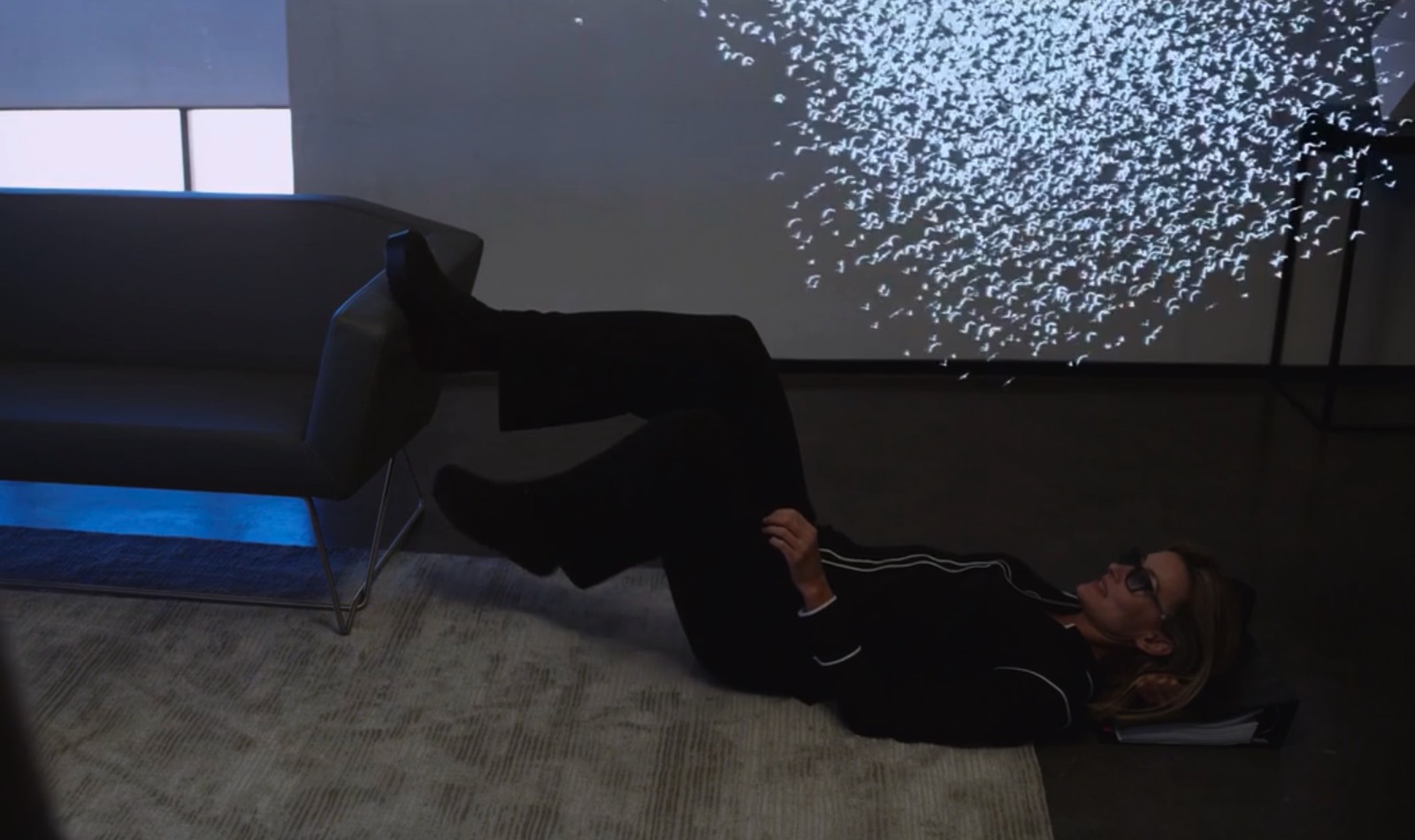 A person on the floor watching AR content playing on the glasses.