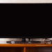 tv on a wooden tv stand, turned off