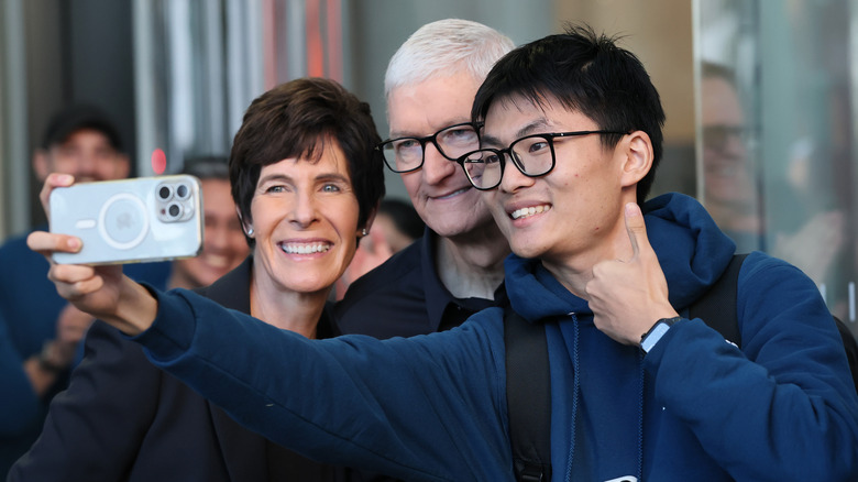 Deirdre O'Brien Apple's Senior Vice President of Retail and People and Apple CEO Tim Cook take a selfie with a customer at the Fifth Avenue Apple Store on new product launch day on September 19, 2025.