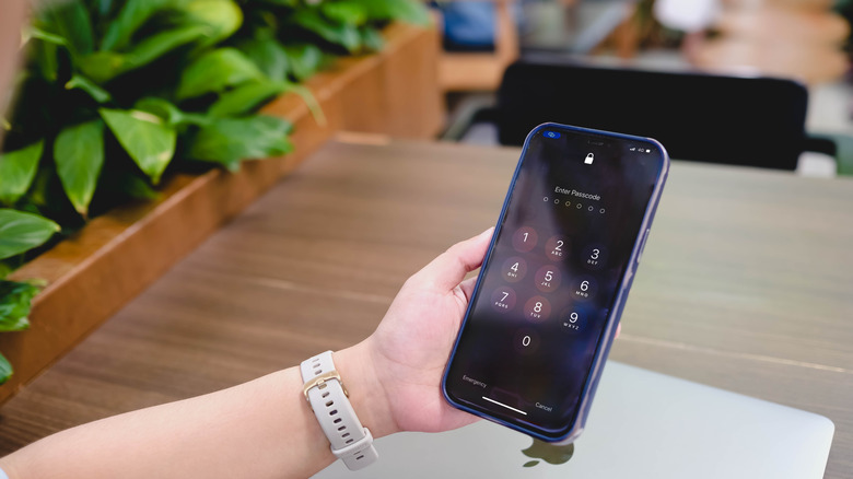 An iPhone Lock Screen showing a lock icon under the notch to indicate the handset is locked.